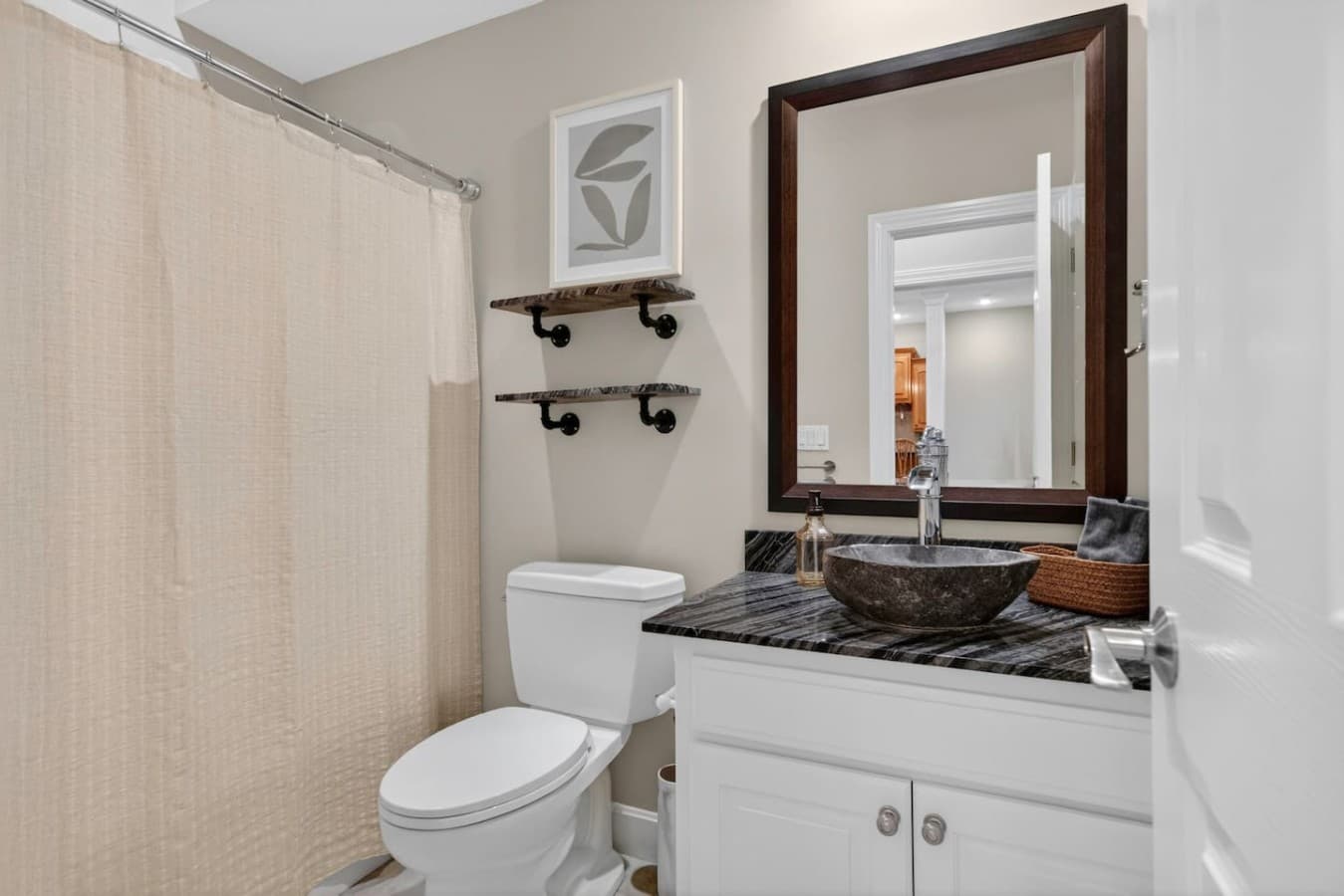 Modern bathroom with granite countertops, vessel sink details, and a clean functional layout for guests.