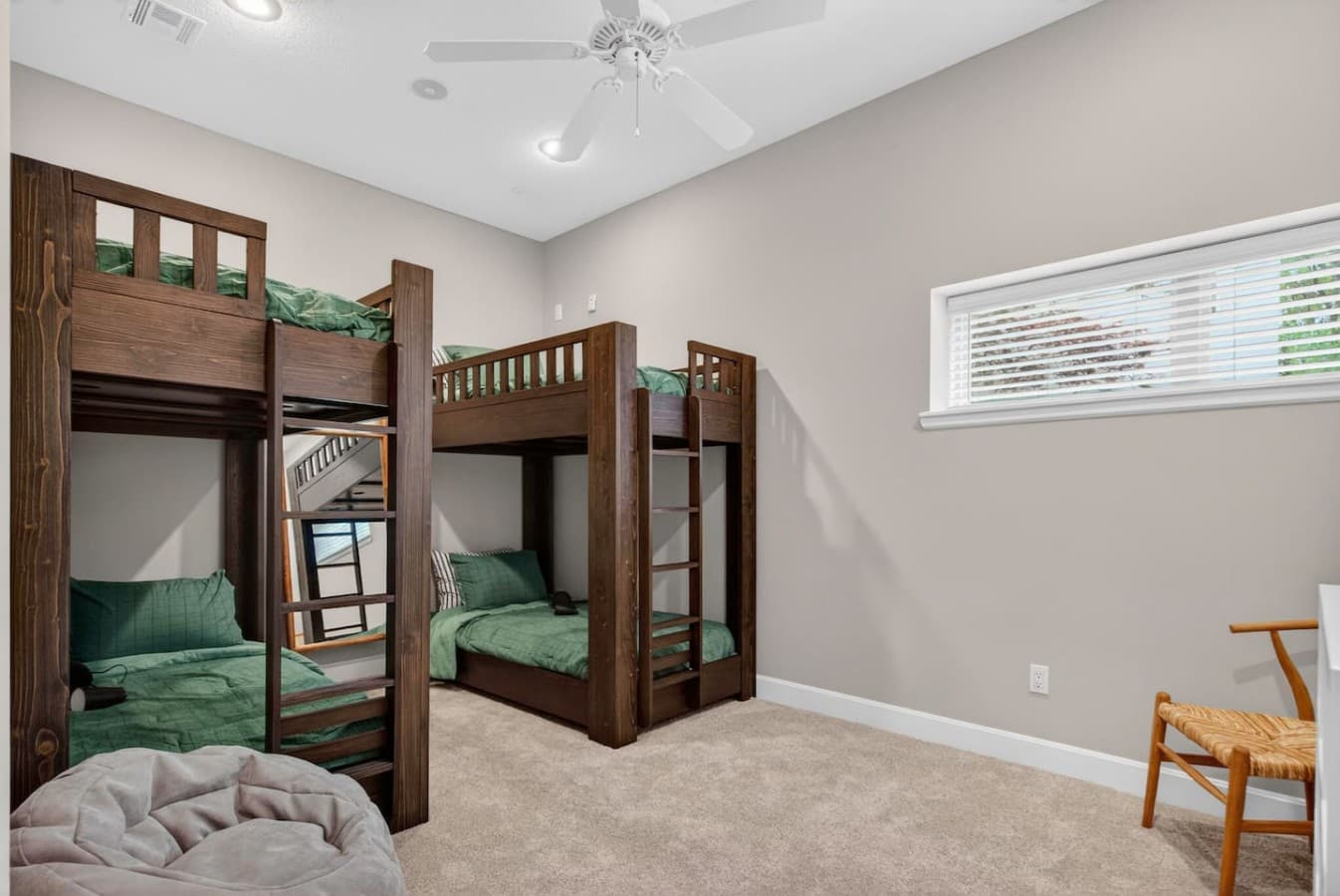 Fun bunk room with multiple beds, soft carpeting, and plenty of space for kids, groups, or sleepovers.