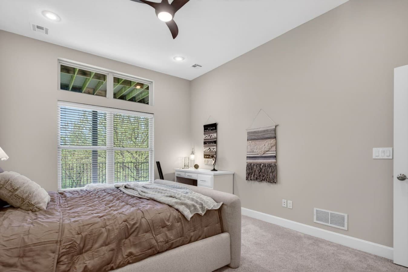 Spacious guest bedroom featuring abundant natural light and a cozy relaxing atmosphere.