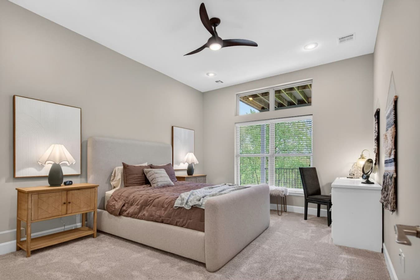 Peaceful bedroom retreat with oversized windows, plush carpeting, and calming wooded views.