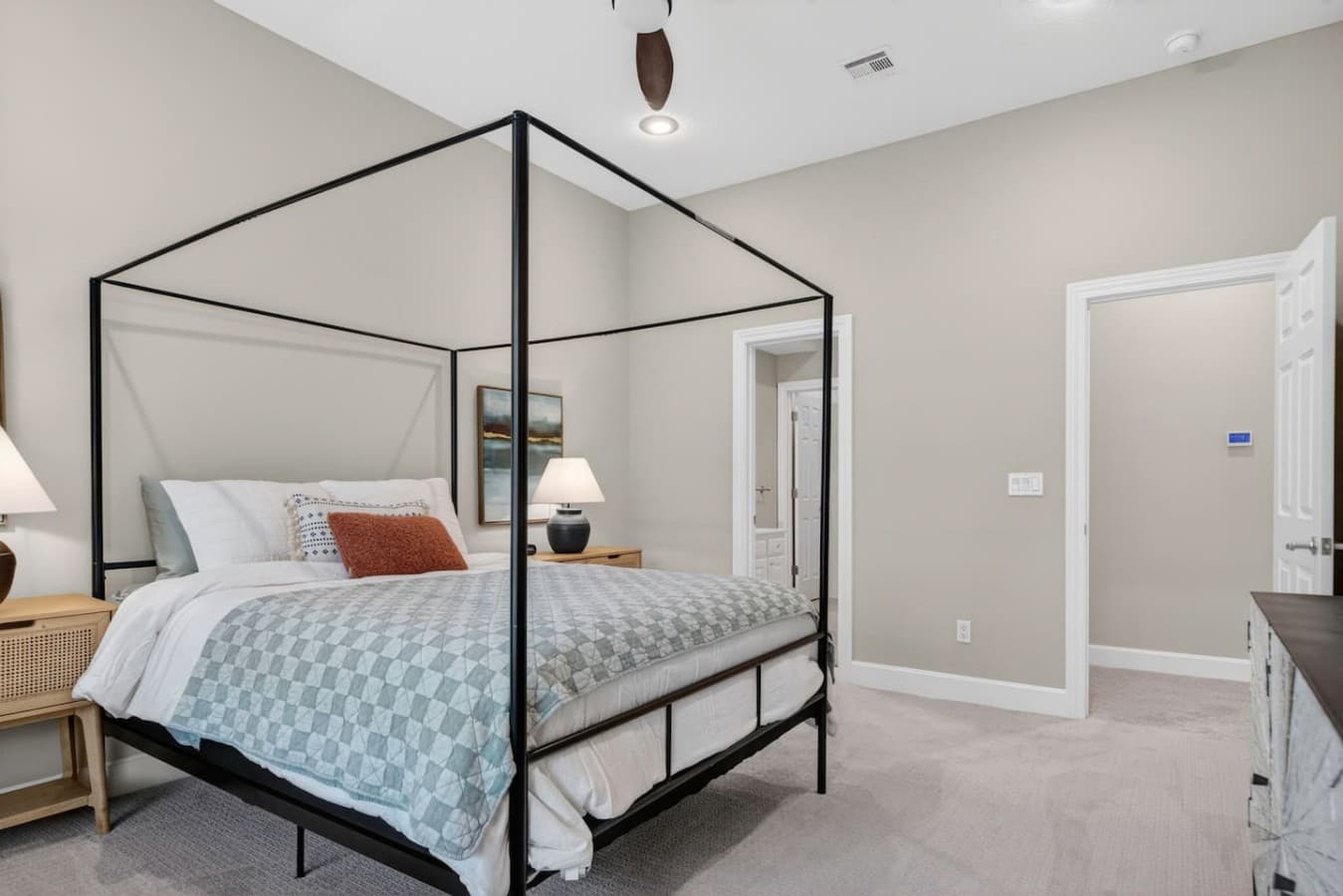 Cozy guest bedroom featuring a modern canopy bed, soft neutral tones, and a calm relaxing atmosphere.