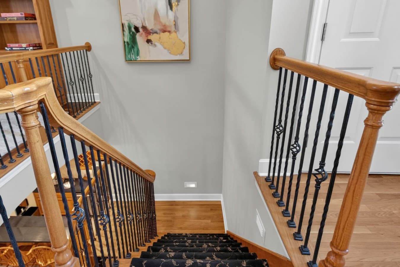 Elegant staircase with wood accents and iron railings creating a warm welcoming entrance.