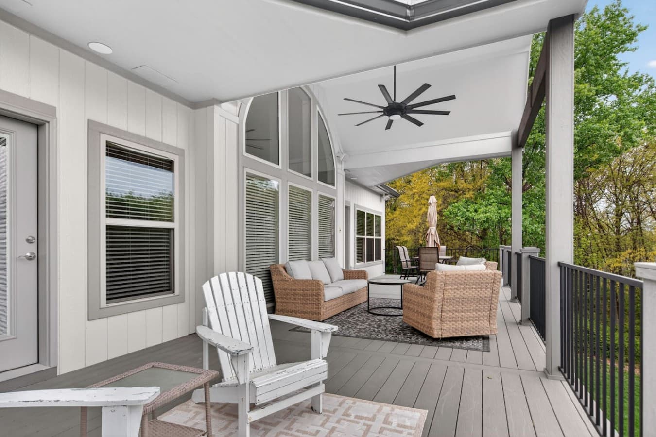 Spacious covered patio with multiple seating areas and seamless indoor outdoor living.