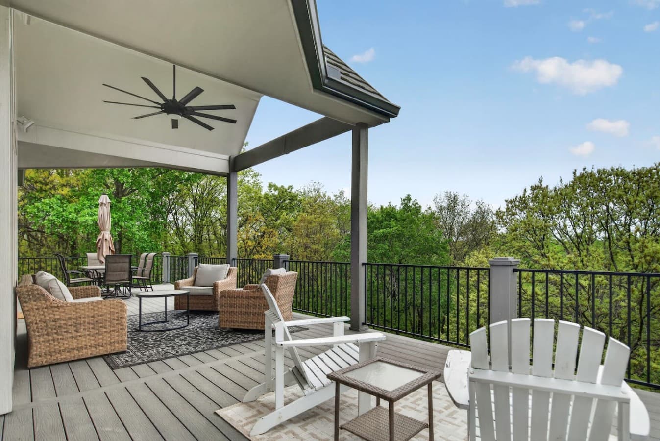 Covered outdoor deck with comfortable lounge seating, scenic treetop views, and a peaceful space to unwind outdoors.