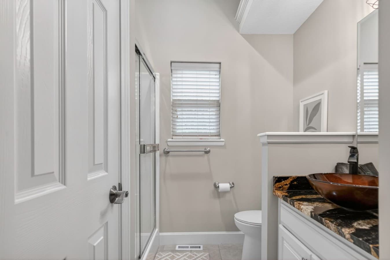 Compact guest bathroom with a clean modern design, walk in shower, and convenient essentials for a comfortable stay.