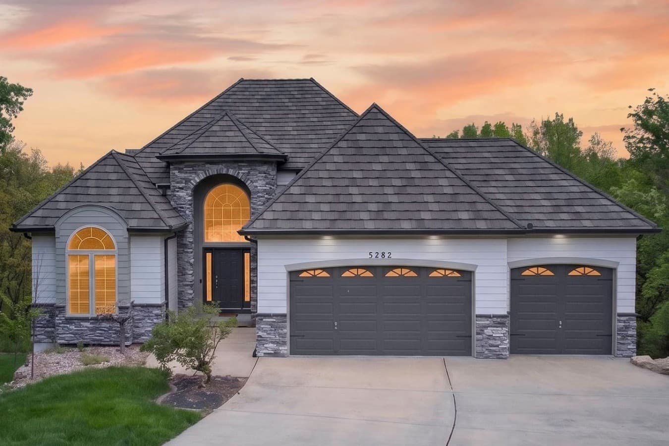 Elegant front facade with dramatic architectural details and warm evening lighting.