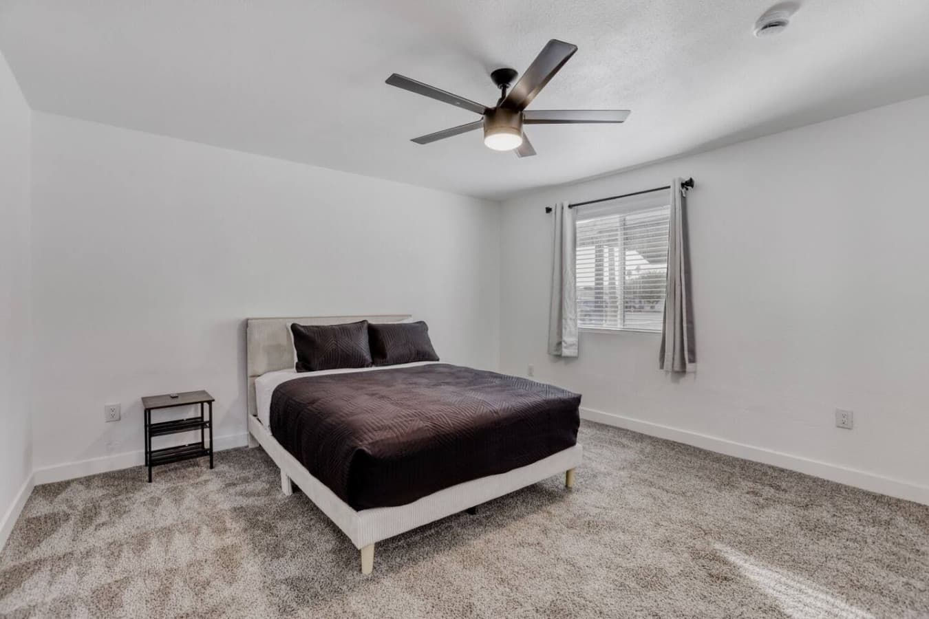 Bedroom with cozy bed and ceiling fan.