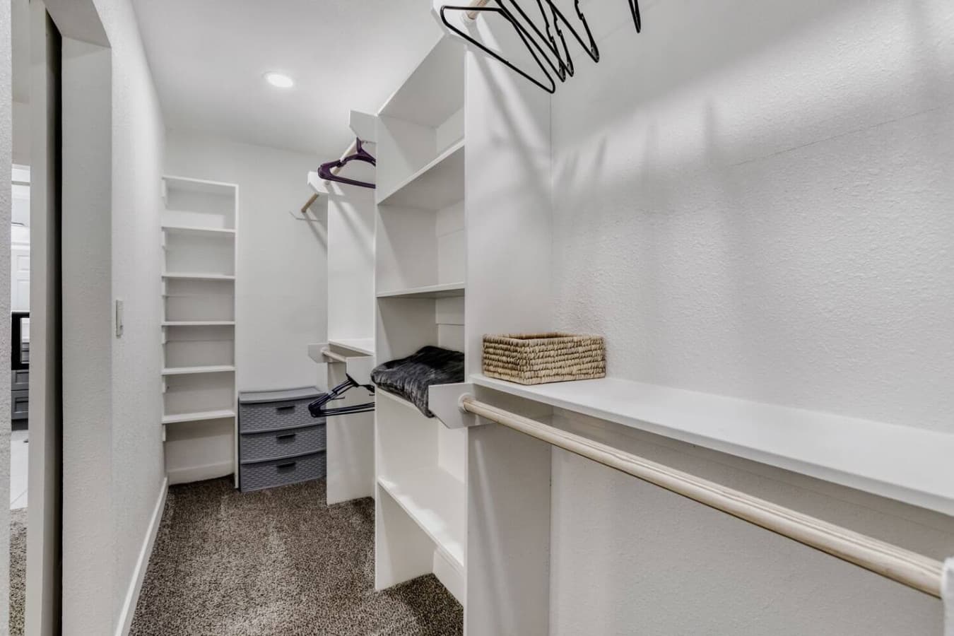 Walk in closet with shelving and hanging space.