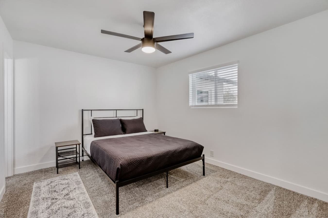 Bedroom with comfortable bed and ceiling fan.