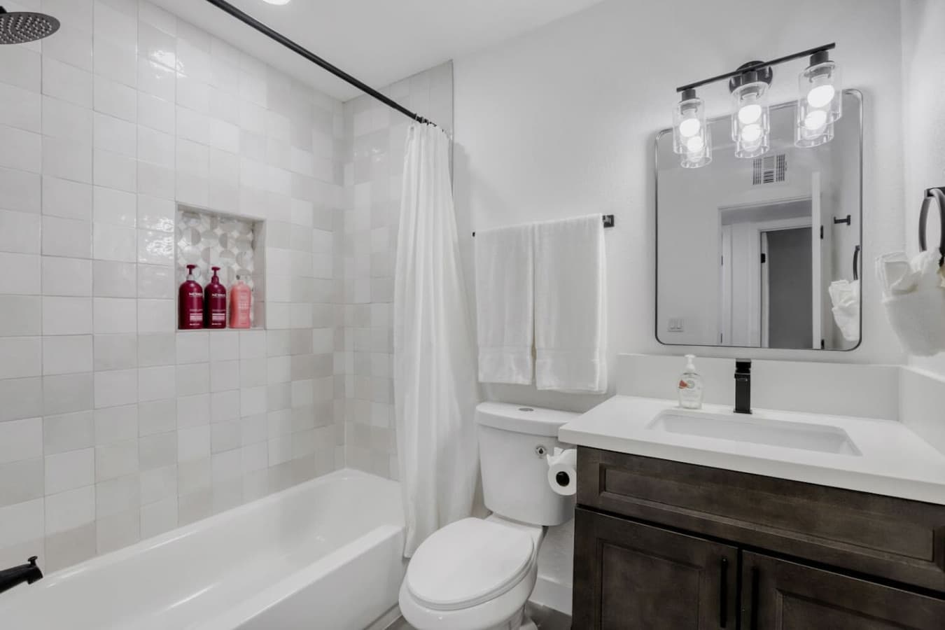 Full bathroom with tub and clean finishes.