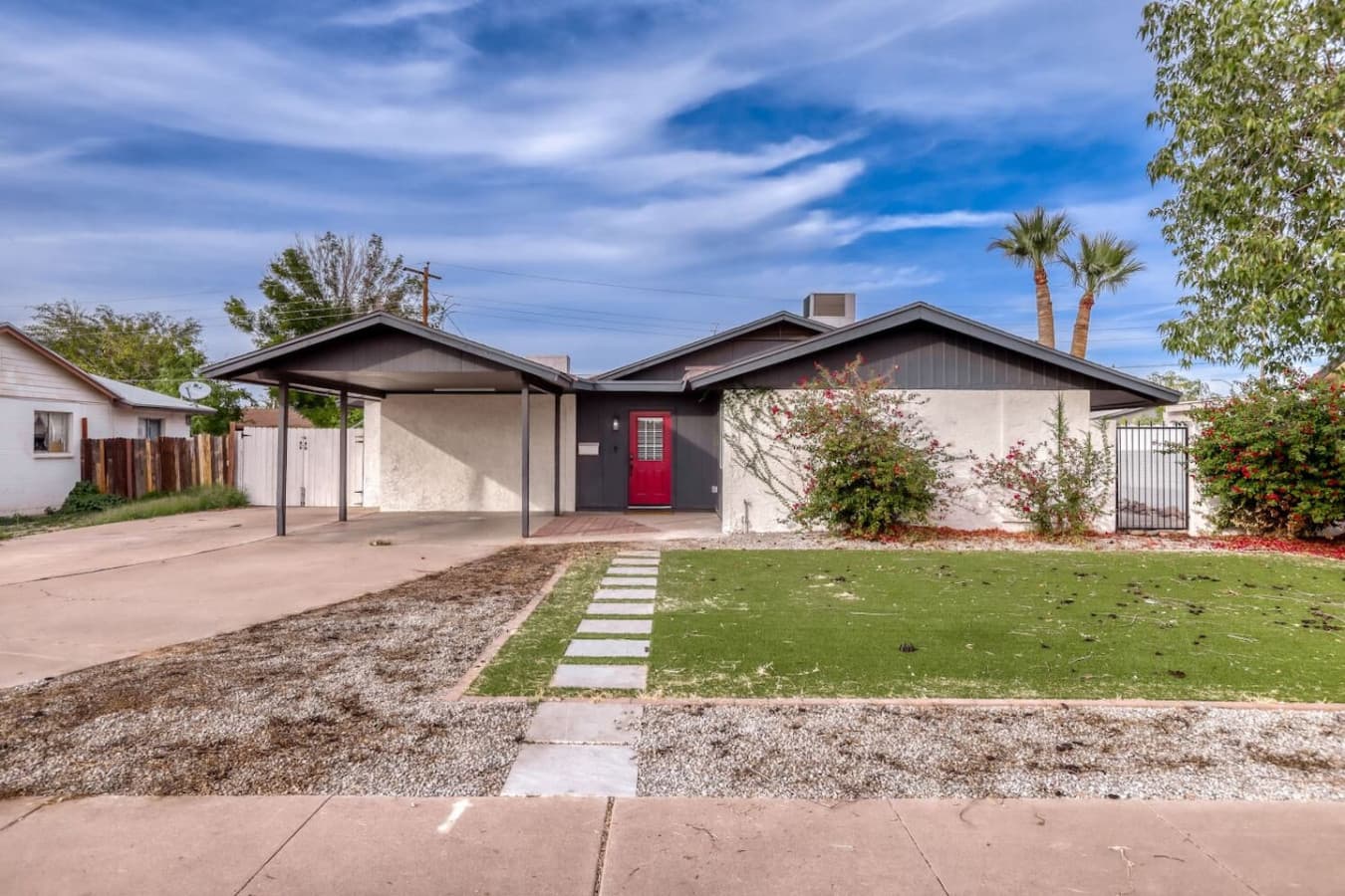 Front yard with walkway and landscaped lawn.