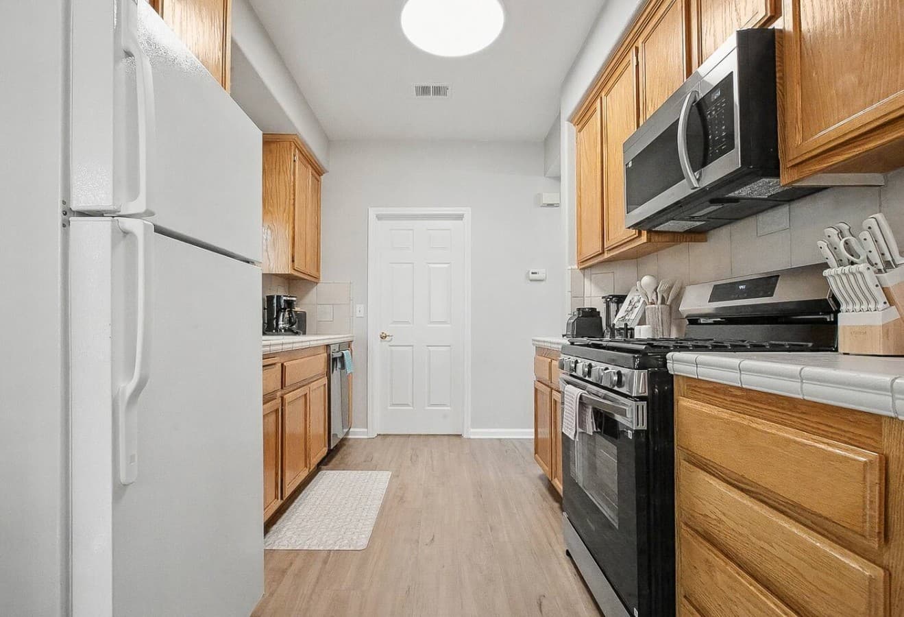 Bright galley kitchen with full size appliances and everything needed for home cooked meals.
