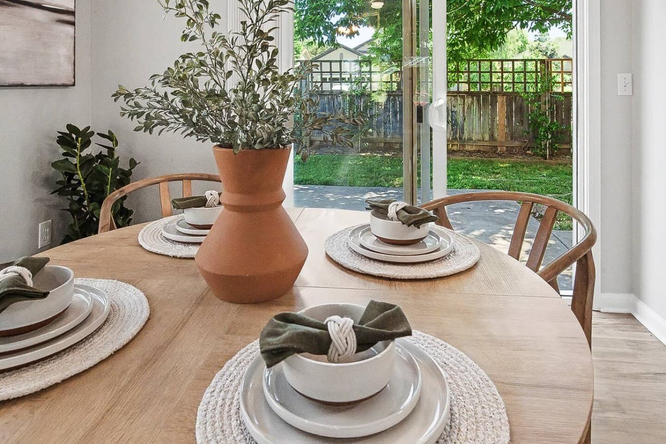 Thoughtfully styled dining table with backyard views and a peaceful atmosphere.