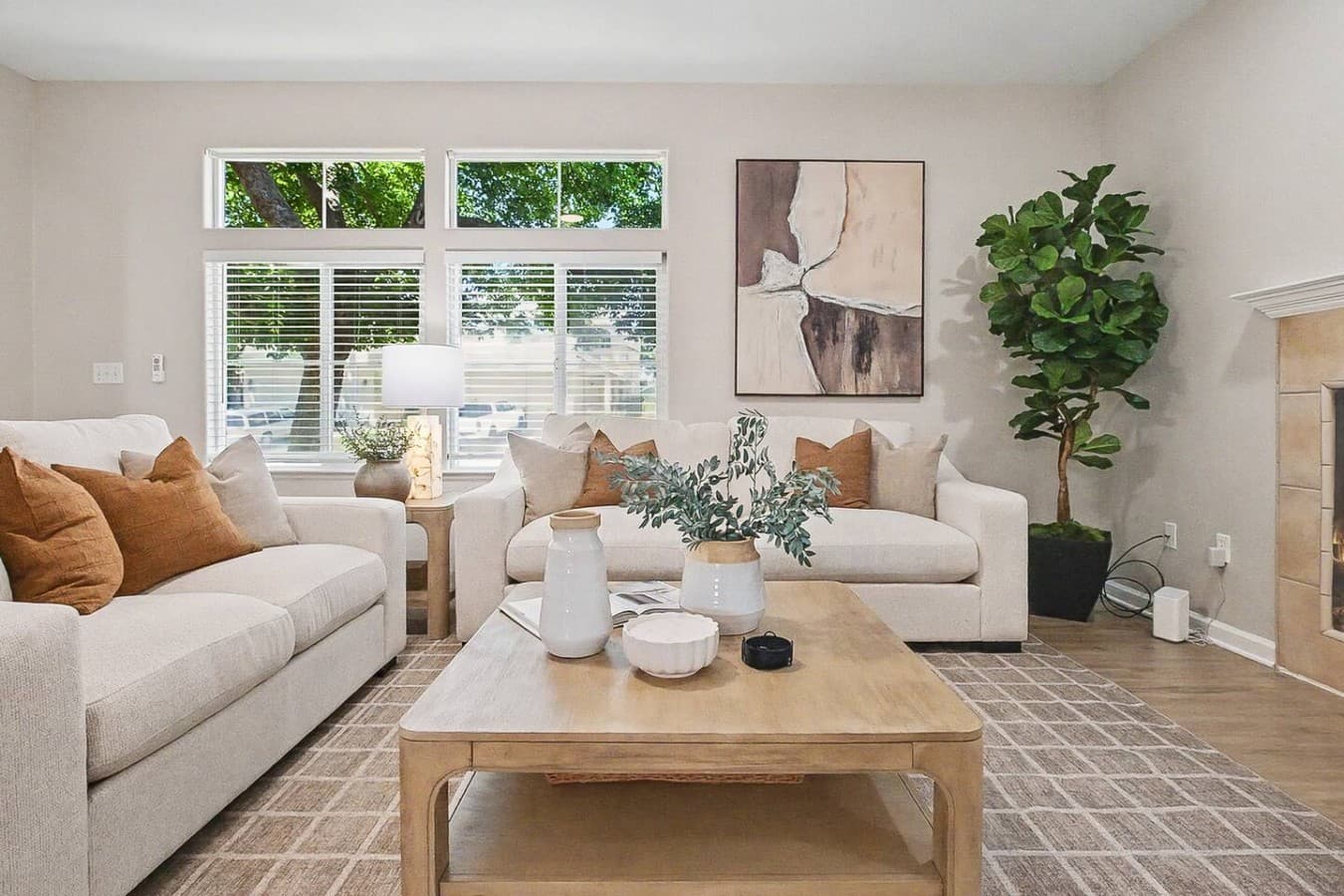 Bright living room with comfortable seating and large windows throughout.