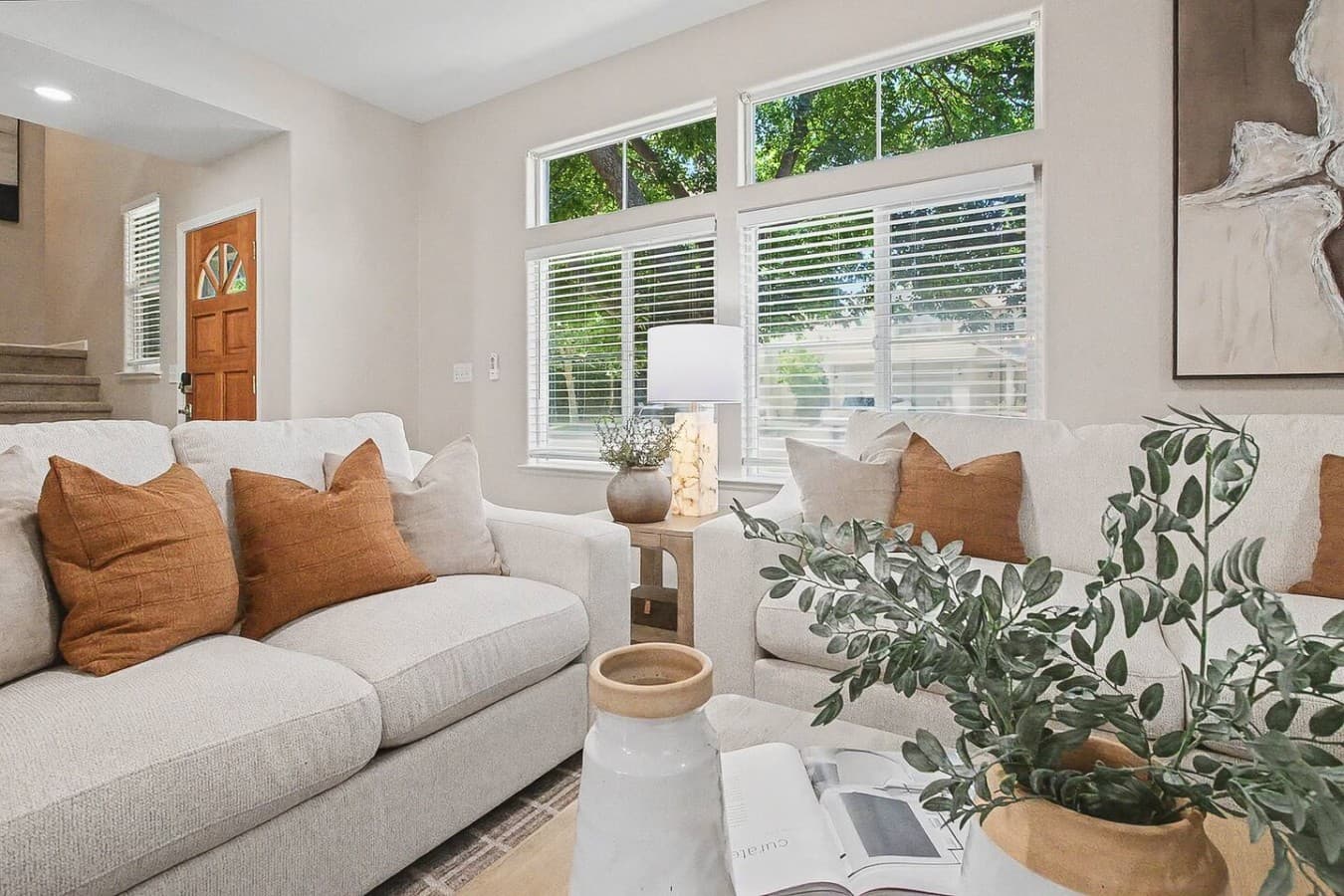 Sunlit sitting area with large windows and calming neutral decor throughout.