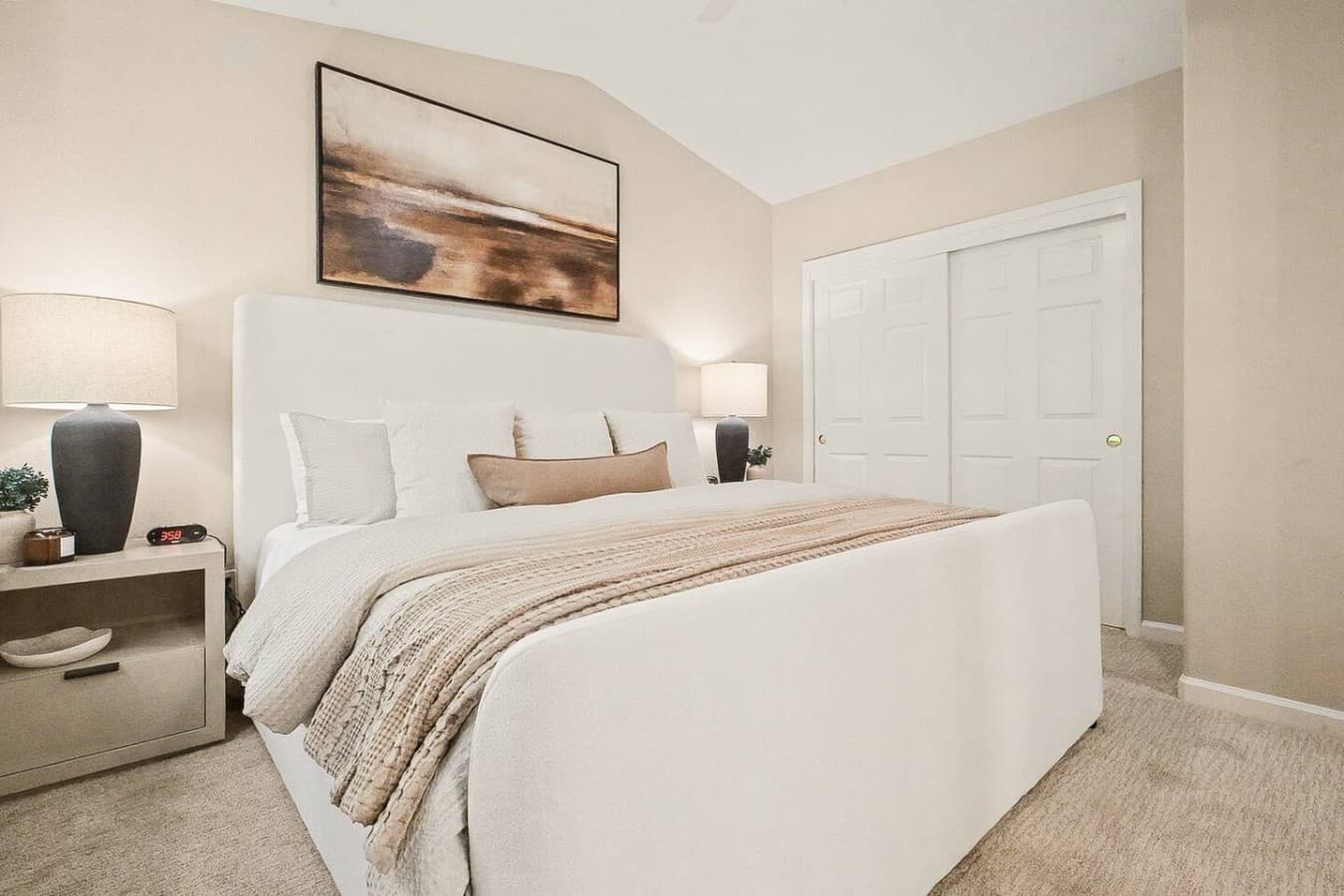 Comfortable king bedroom featuring layered linens and calming decor throughout.