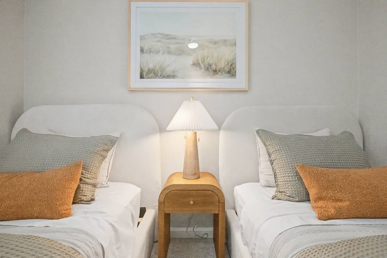 Shared bedside table setup with warm lighting and peaceful decor details.