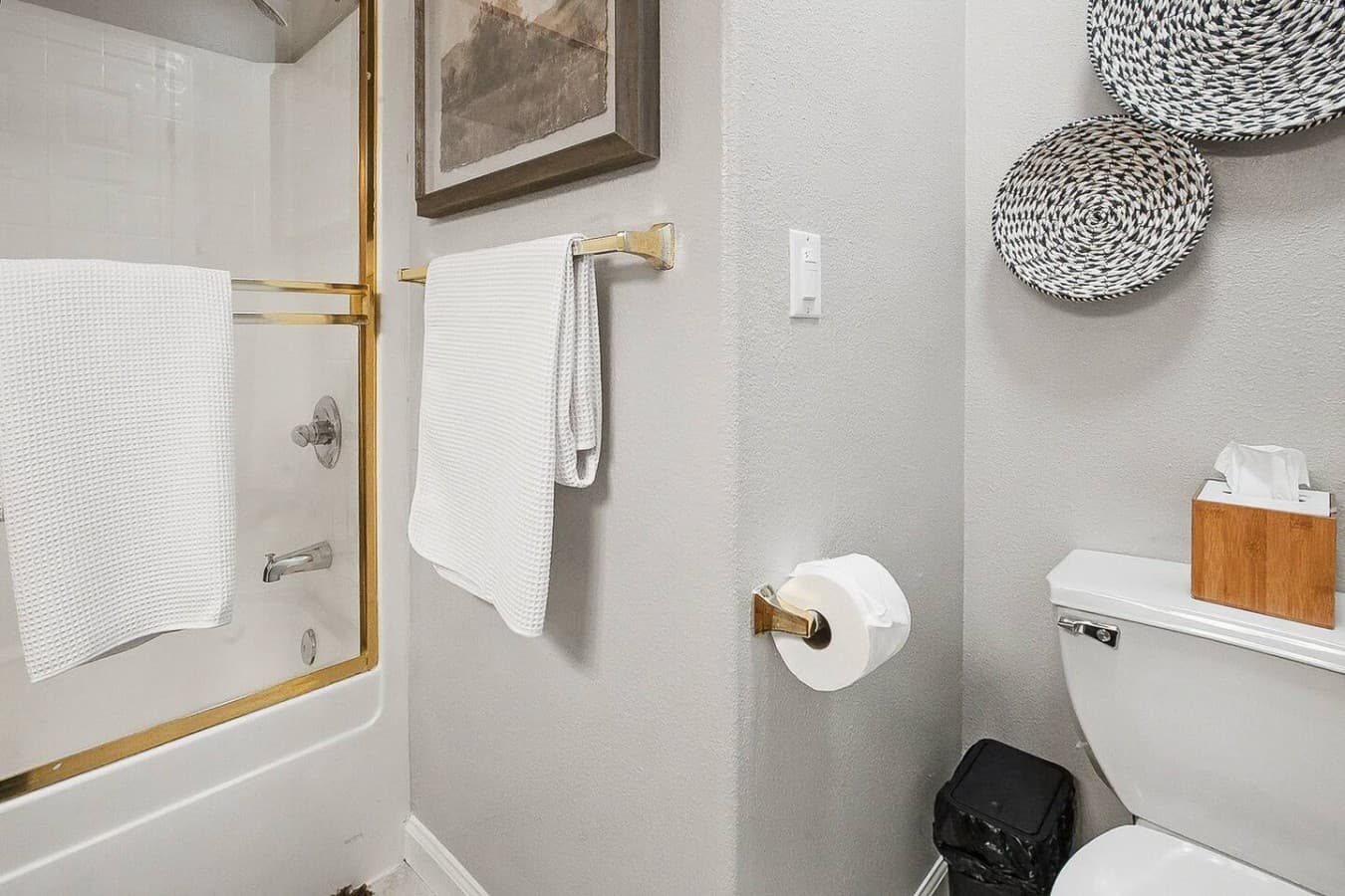 Full bathroom with shower and tub combination stocked with fresh towels.