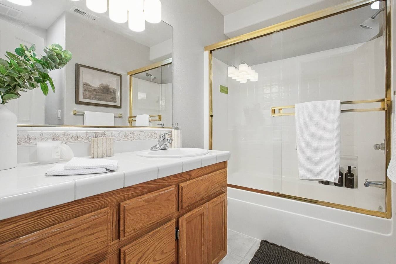 Clean and functional bathroom with a large mirror and glass shower enclosure.
