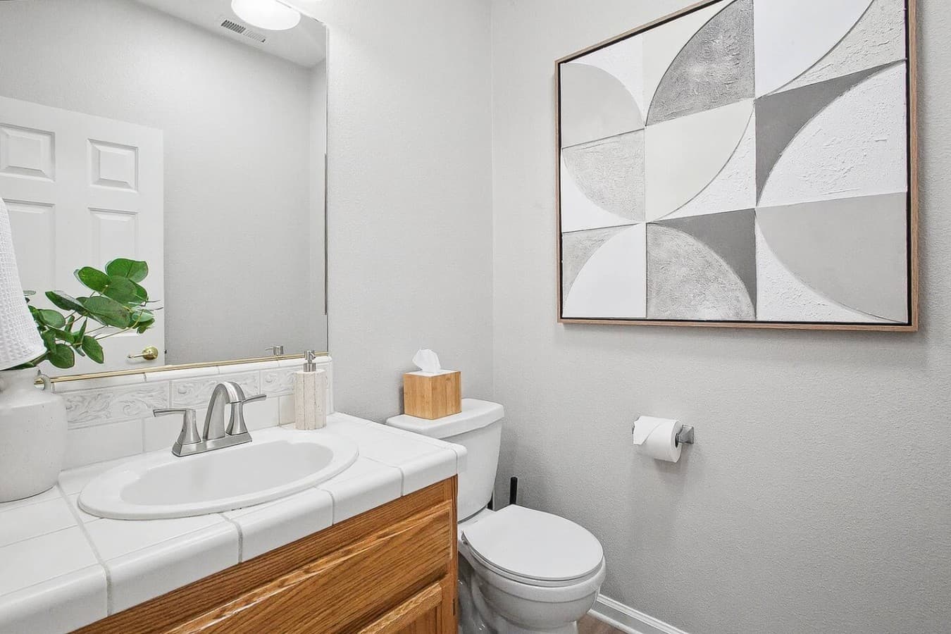 Convenient half bathroom with clean finishes and modern decor accents.