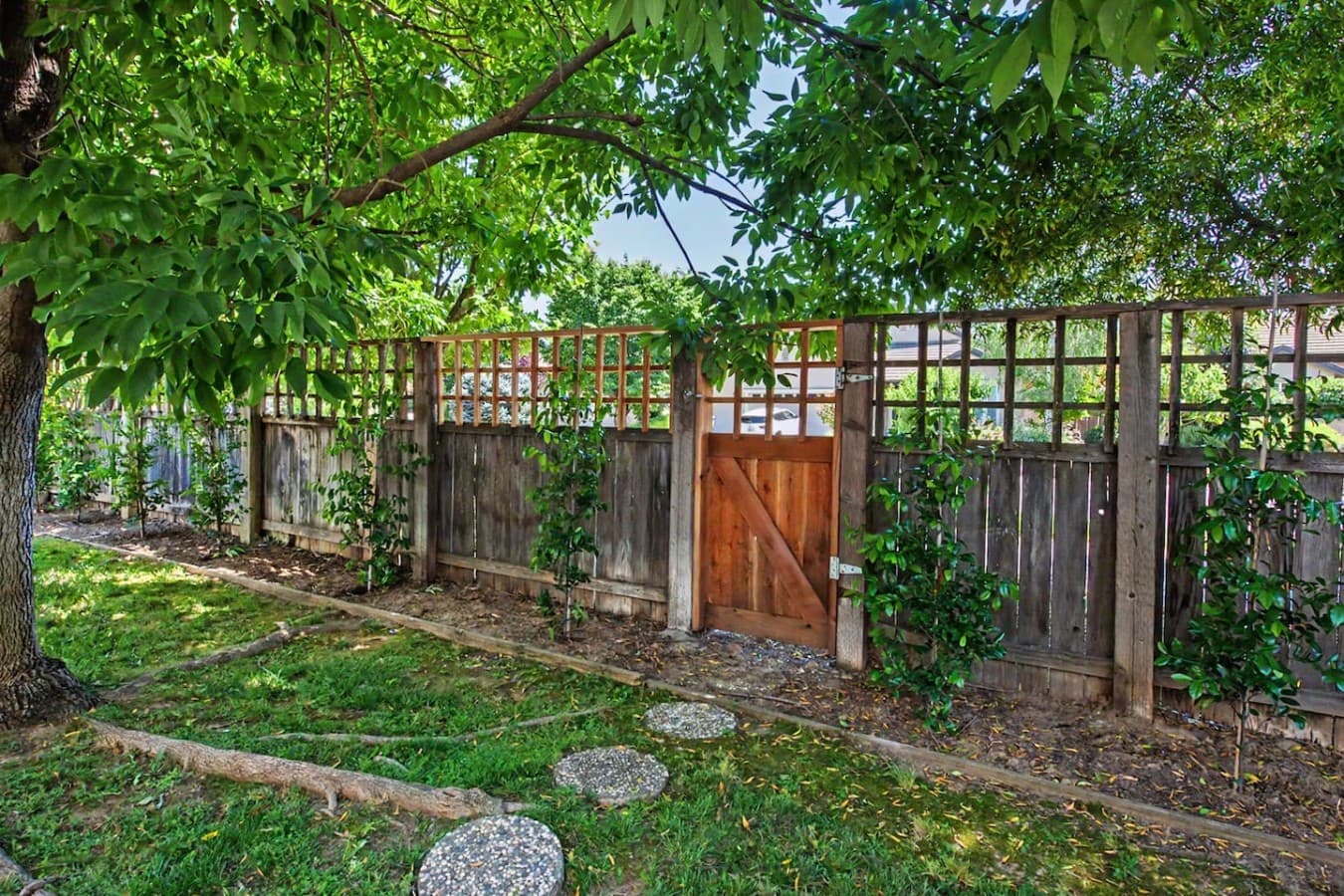 Quiet outdoor space with shaded pathways and a charming garden gate entrance.