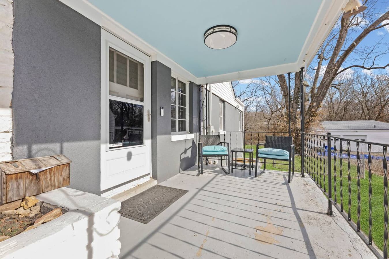 Covered front porch with seating perfect for enjoying fresh air.
