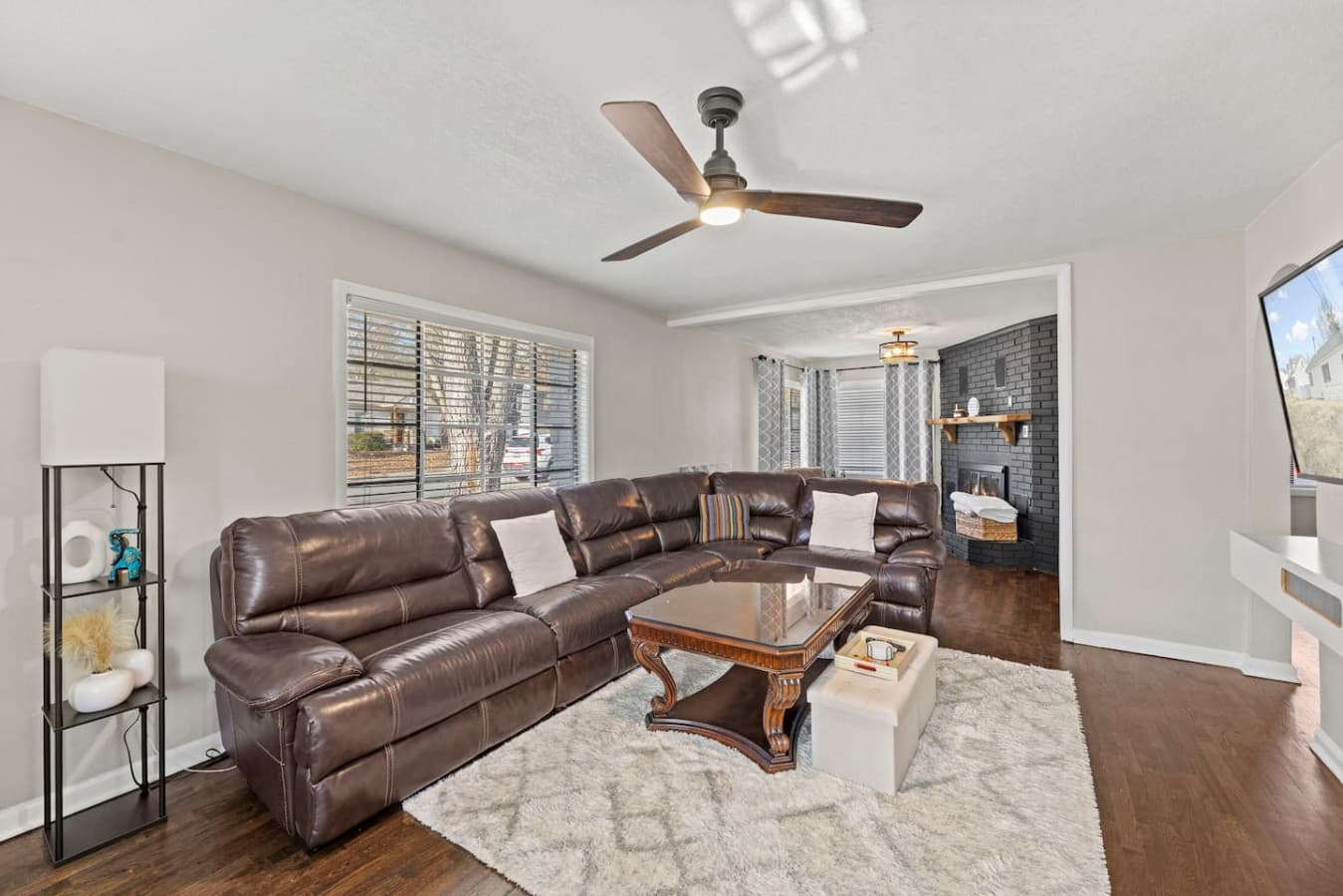 Open layout living area with cozy textures and warm wood floors.