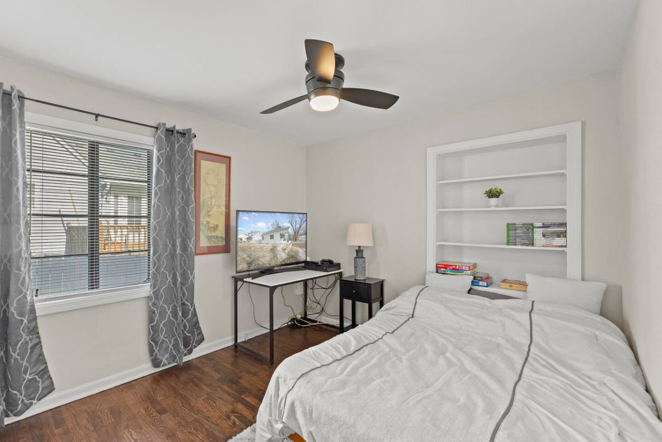 Bright bedroom featuring a workspace and simple thoughtful design.