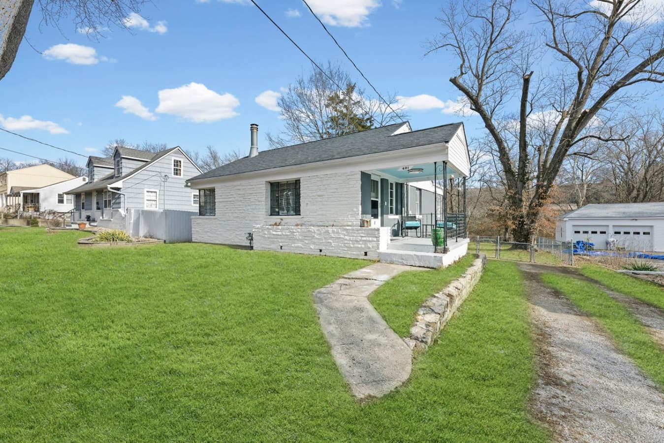 Charming exterior with a spacious lawn and quiet residential setting.