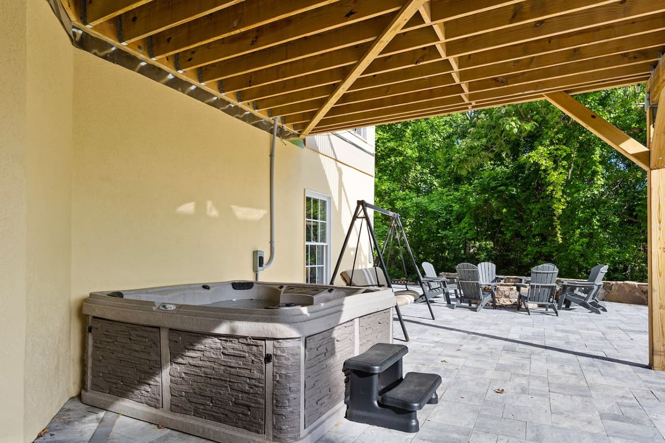 Covered outdoor spa area with a hot tub and relaxing mountain retreat vibes.