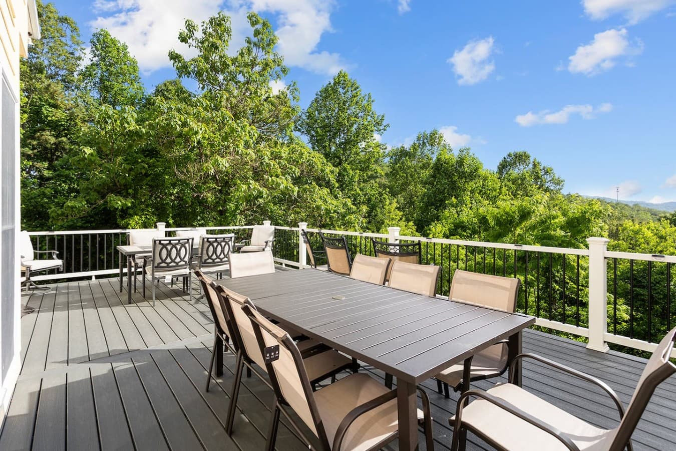 Spacious outdoor dining deck surrounded by peaceful wooded views.