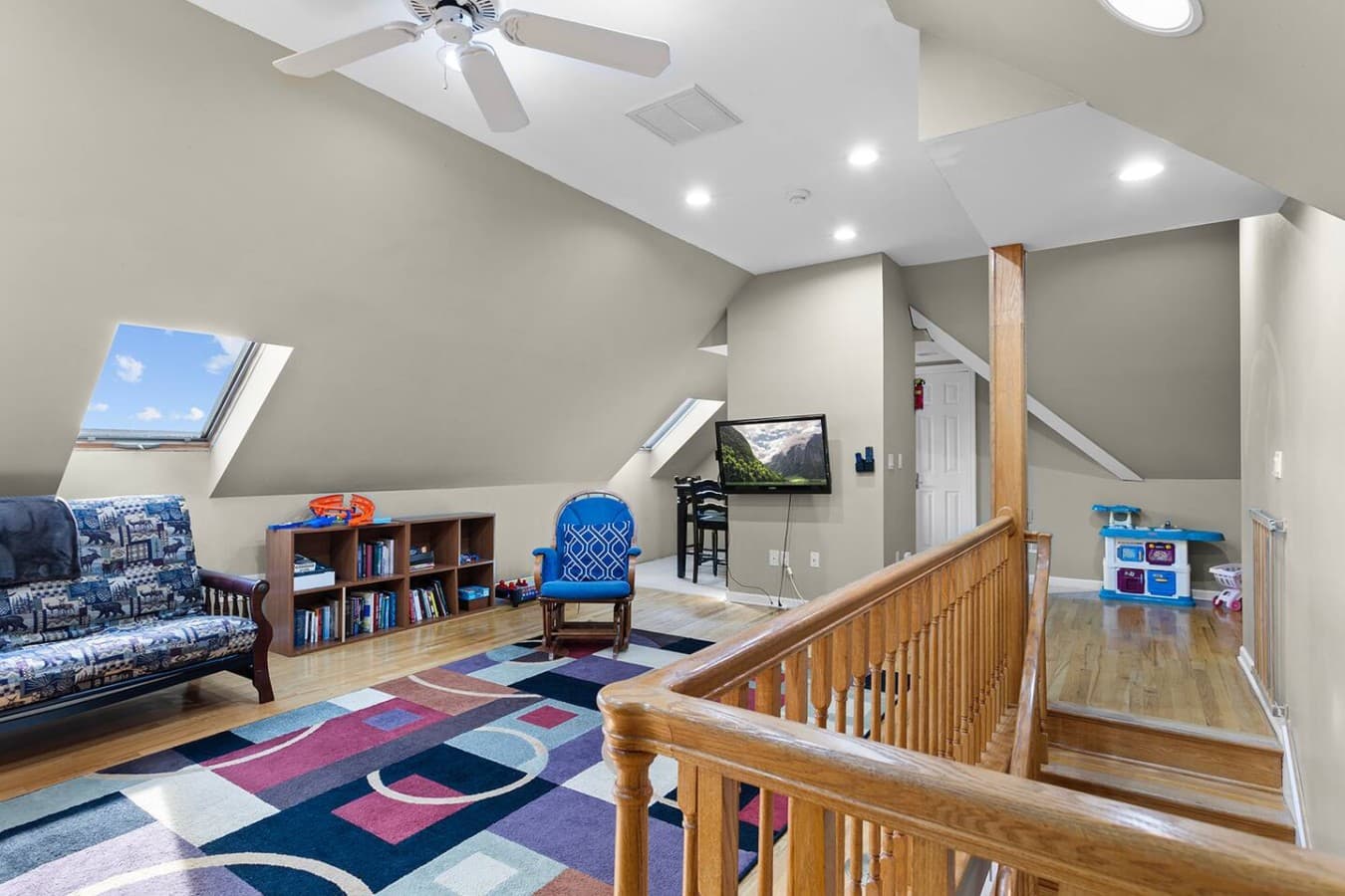 Open loft area with books, games, and extra lounge space overlooking the main level.