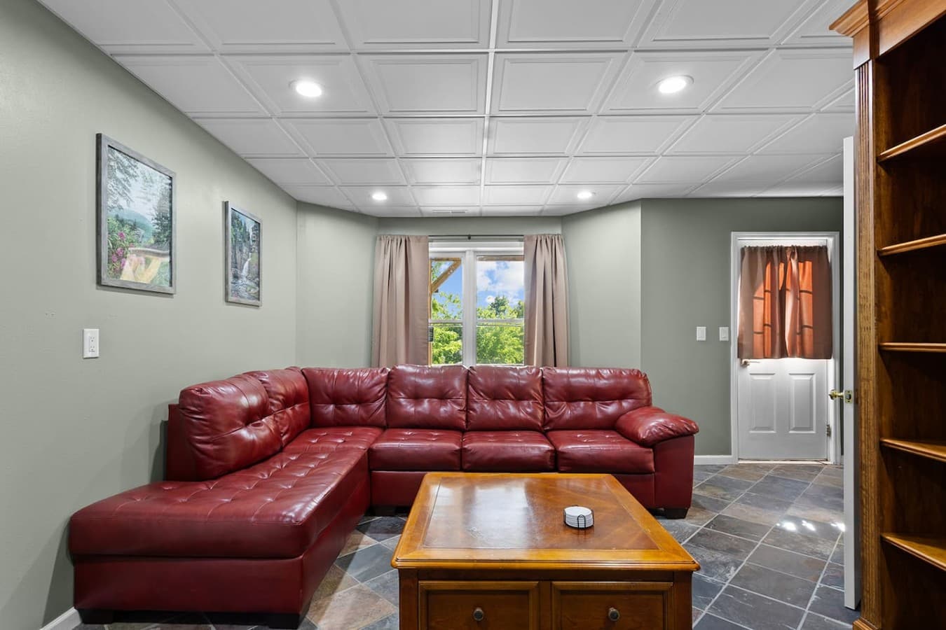 Spacious basement gathering area with comfortable seating and a cozy retreat atmosphere.