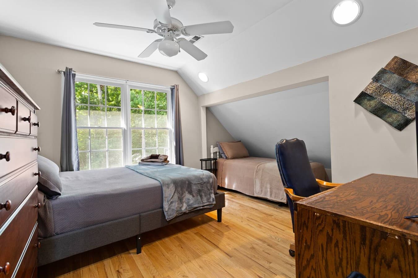 Comfortable bedroom with a dedicated workspace and peaceful natural light.