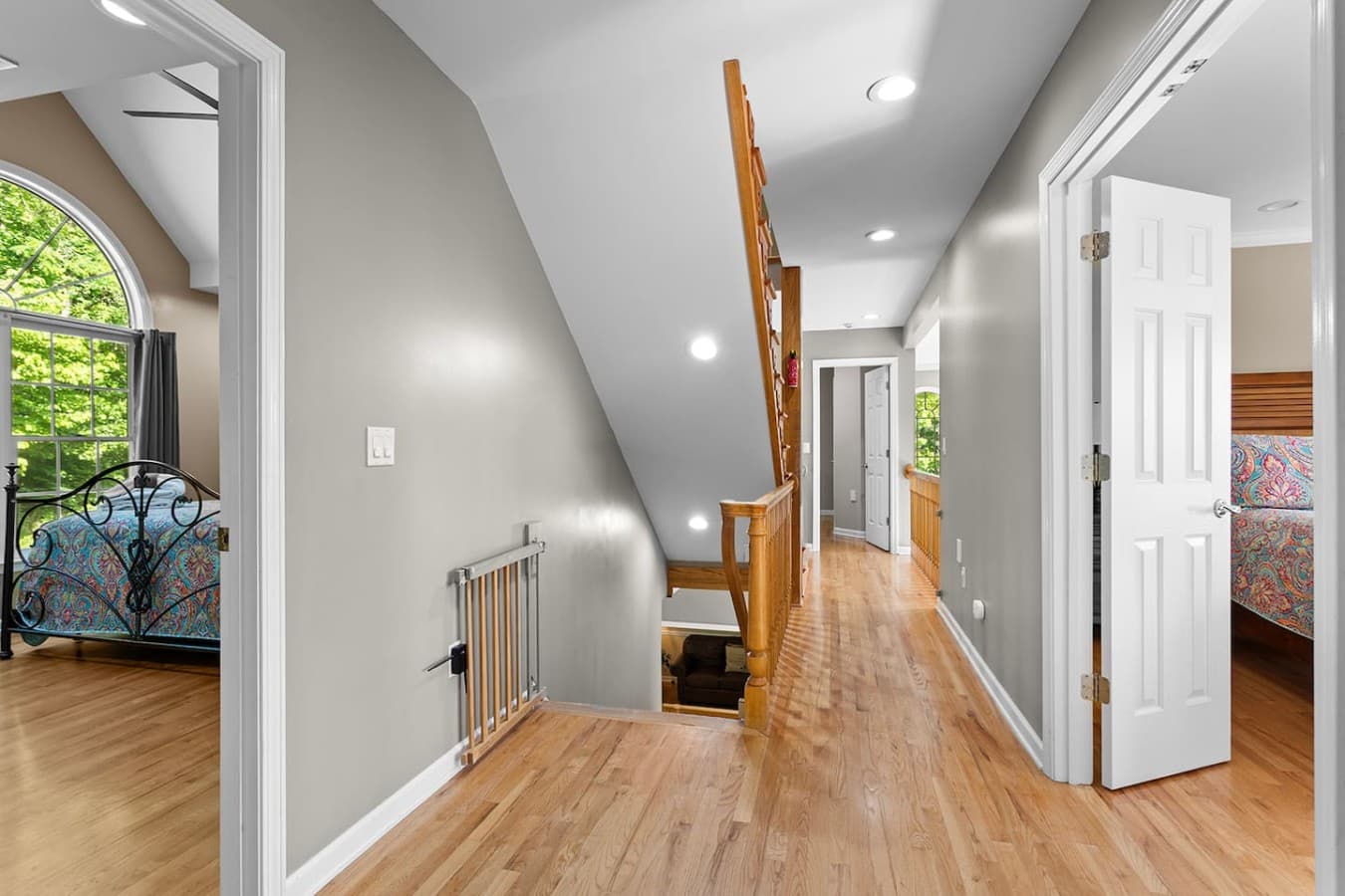 Open upper hallway with hardwood floors and easy access to multiple bedrooms.