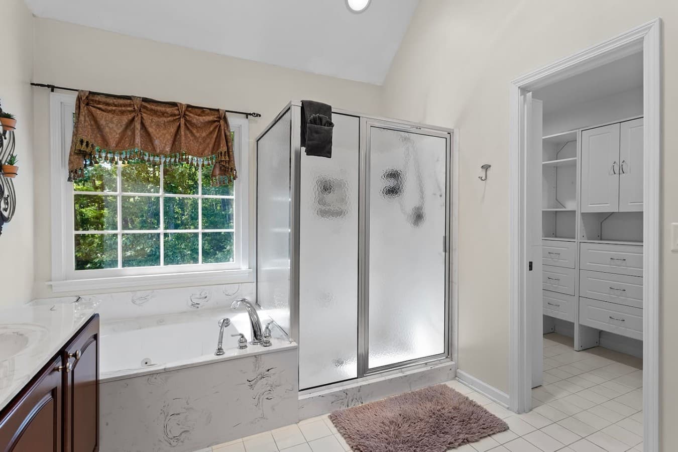 Primary bathroom with a soaking tub, glass shower, and relaxing natural light.