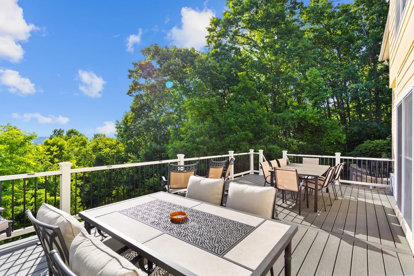 Outdoor dining and lounge area with beautiful treetop and mountain views.