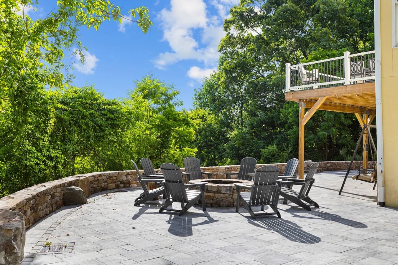 Spacious outdoor fire pit patio surrounded by peaceful wooded mountain scenery.