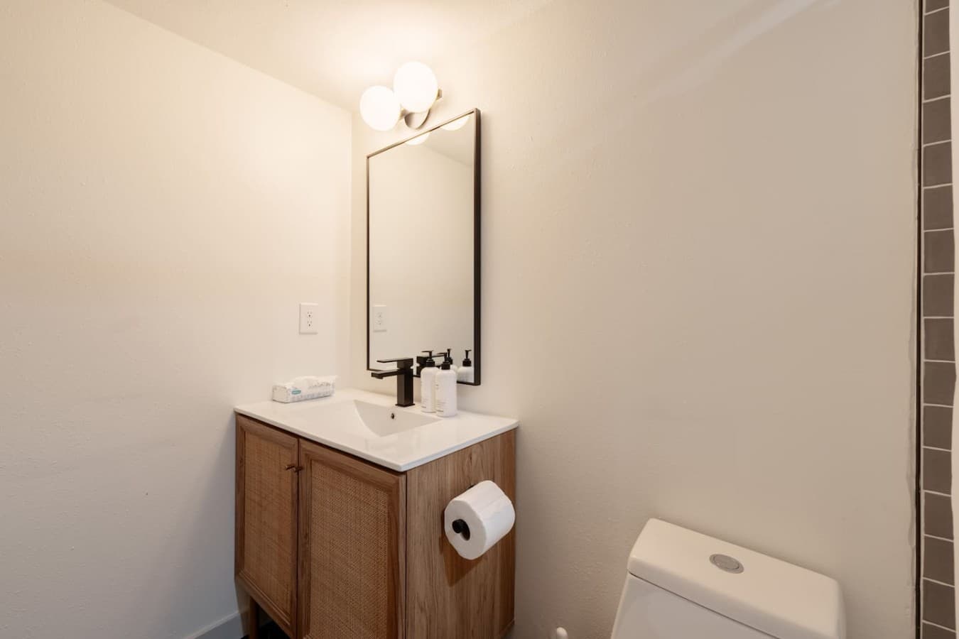 Simple and stylish vanity area with clean design details and convenient storage space for guests.