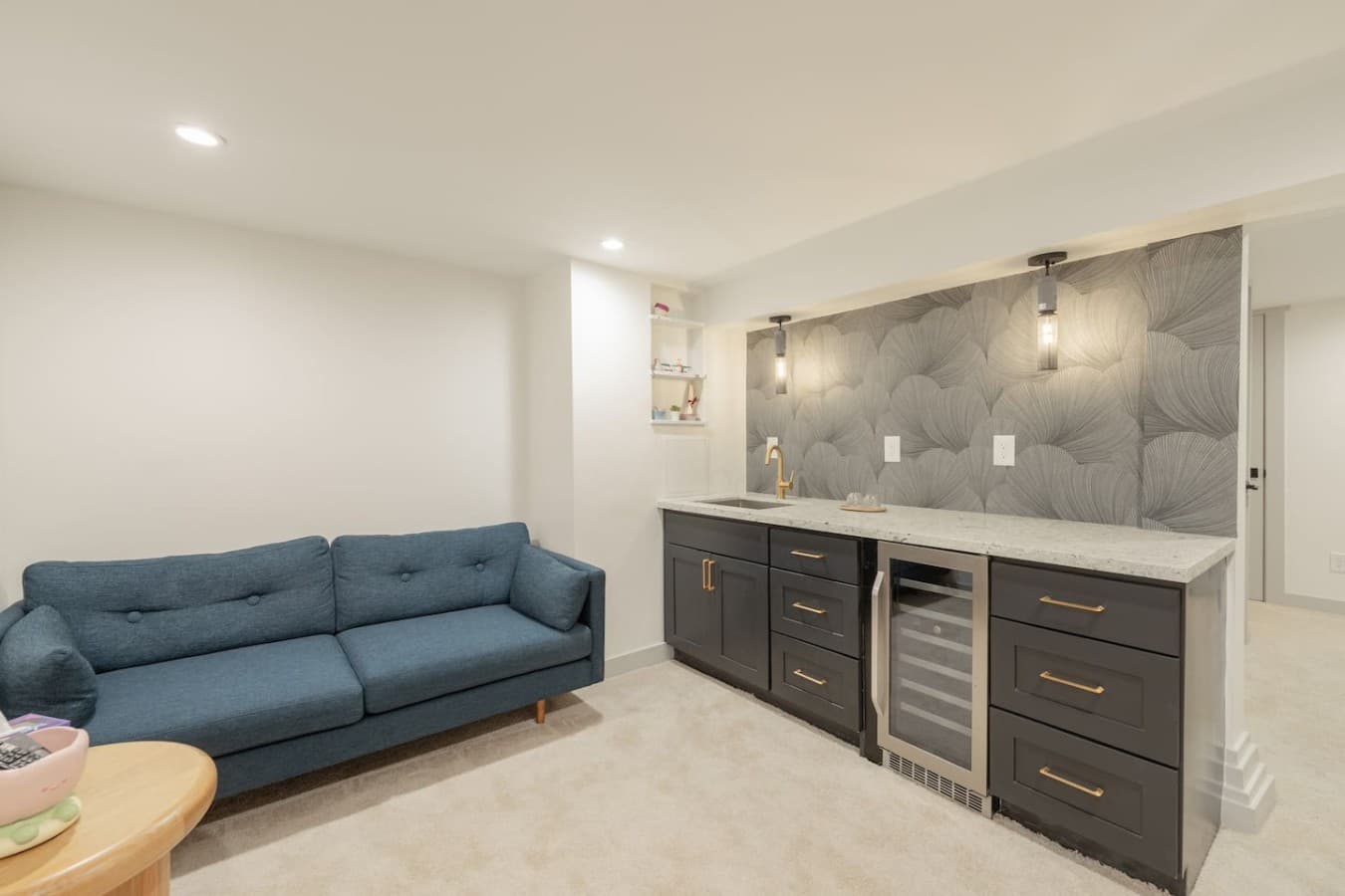 Cozy lower level lounge featuring a stylish wet bar, mini fridge, and comfortable seating area for relaxing evenings indoors.
