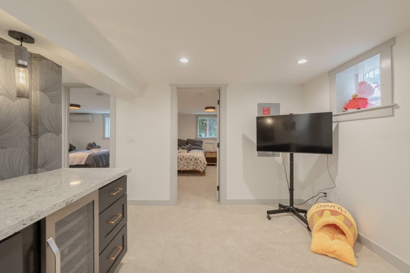 Spacious downstairs entertainment area with comfortable seating and an additional TV space for relaxing together.