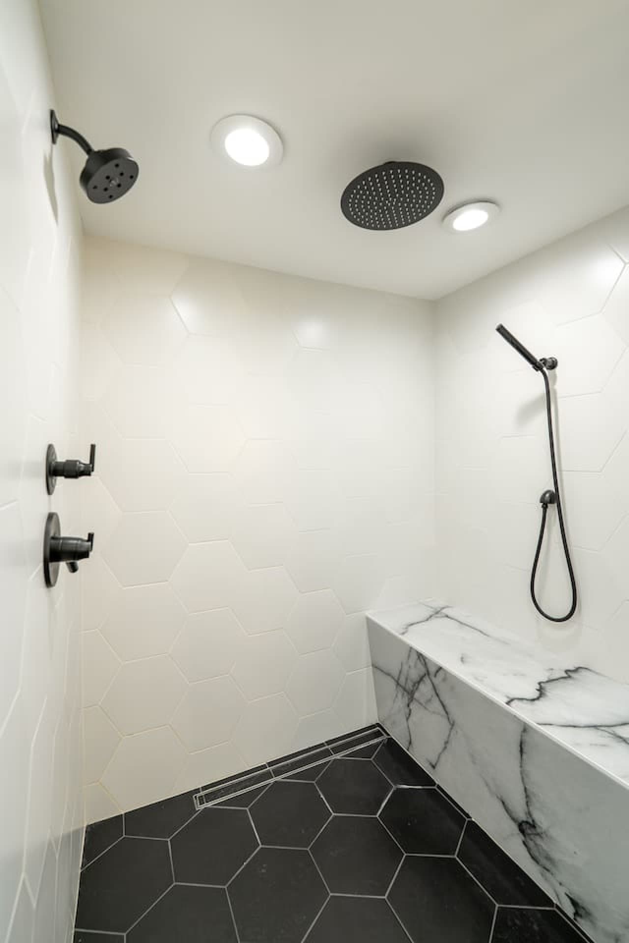 Modern tiled shower with built in bench seating and elegant finishes designed for a relaxing experience.