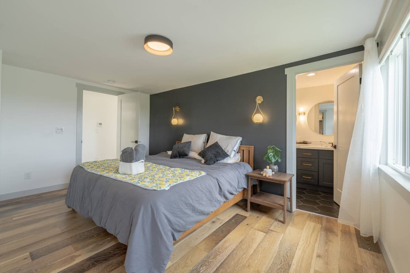 Comfortable bedroom with a cozy bed, modern accents, and direct access to a private ensuite bathroom.