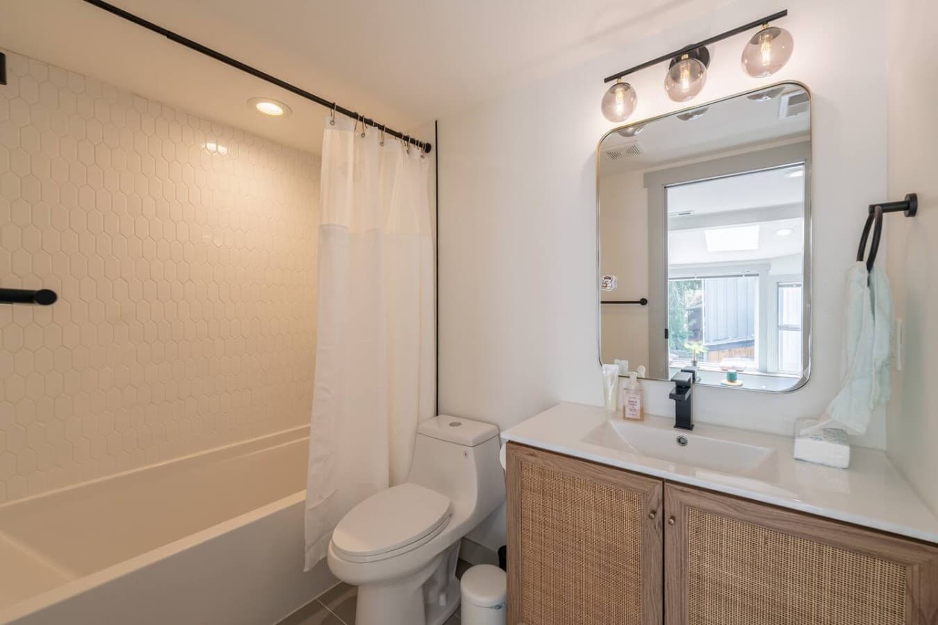 Clean and modern bathroom with a full shower and bright vanity lighting for a fresh start to the day.