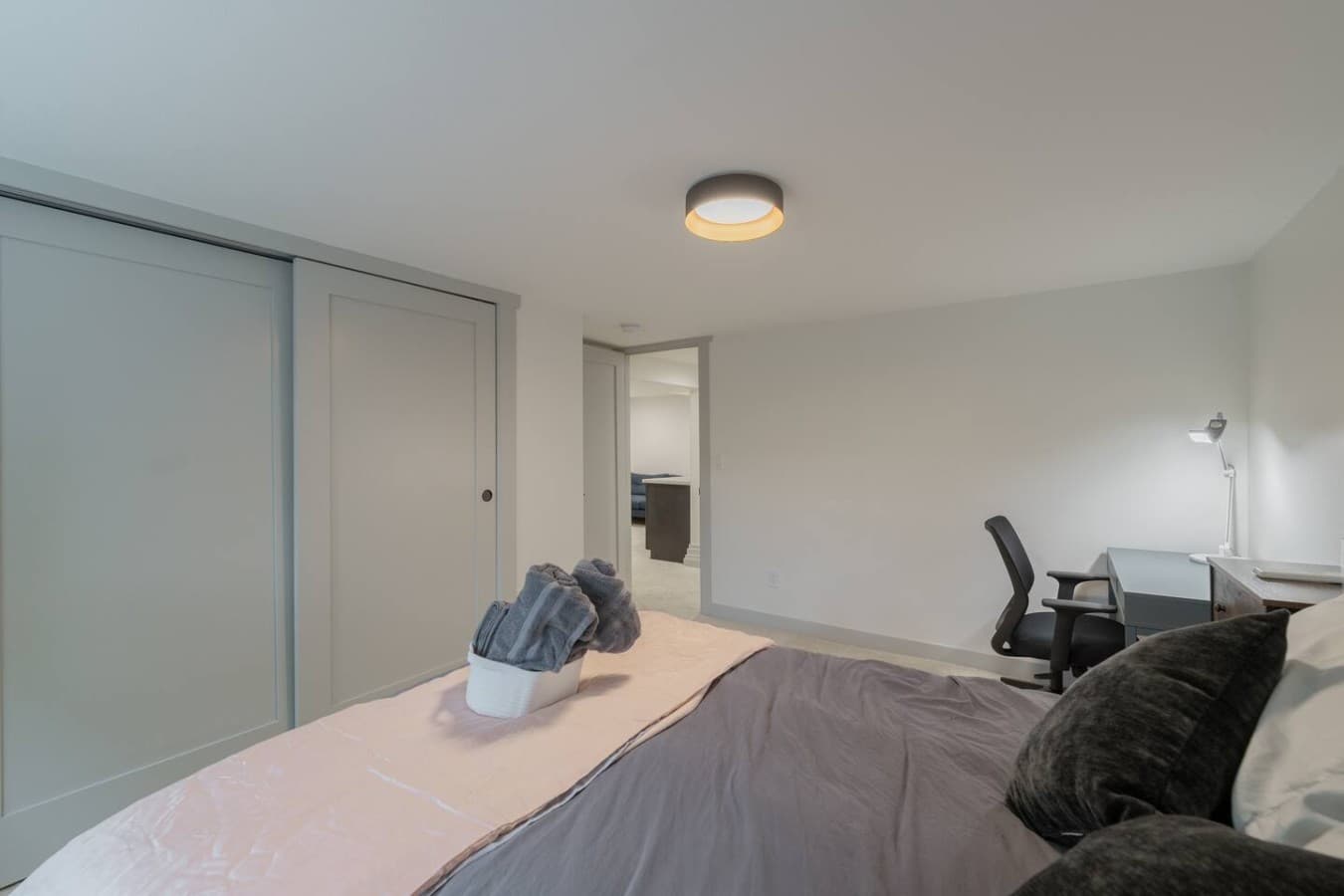 Bright and functional sleeping space featuring ample storage, a work desk, and a peaceful atmosphere for extended visits.