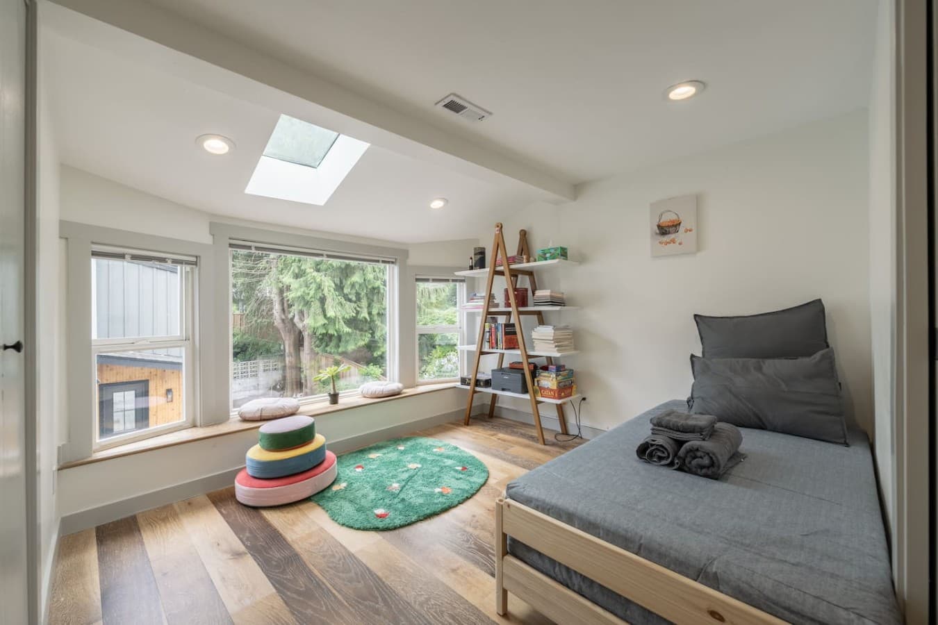 Bright and cozy bedroom with natural light, comfortable sleeping space, and a peaceful reading nook by the windows.