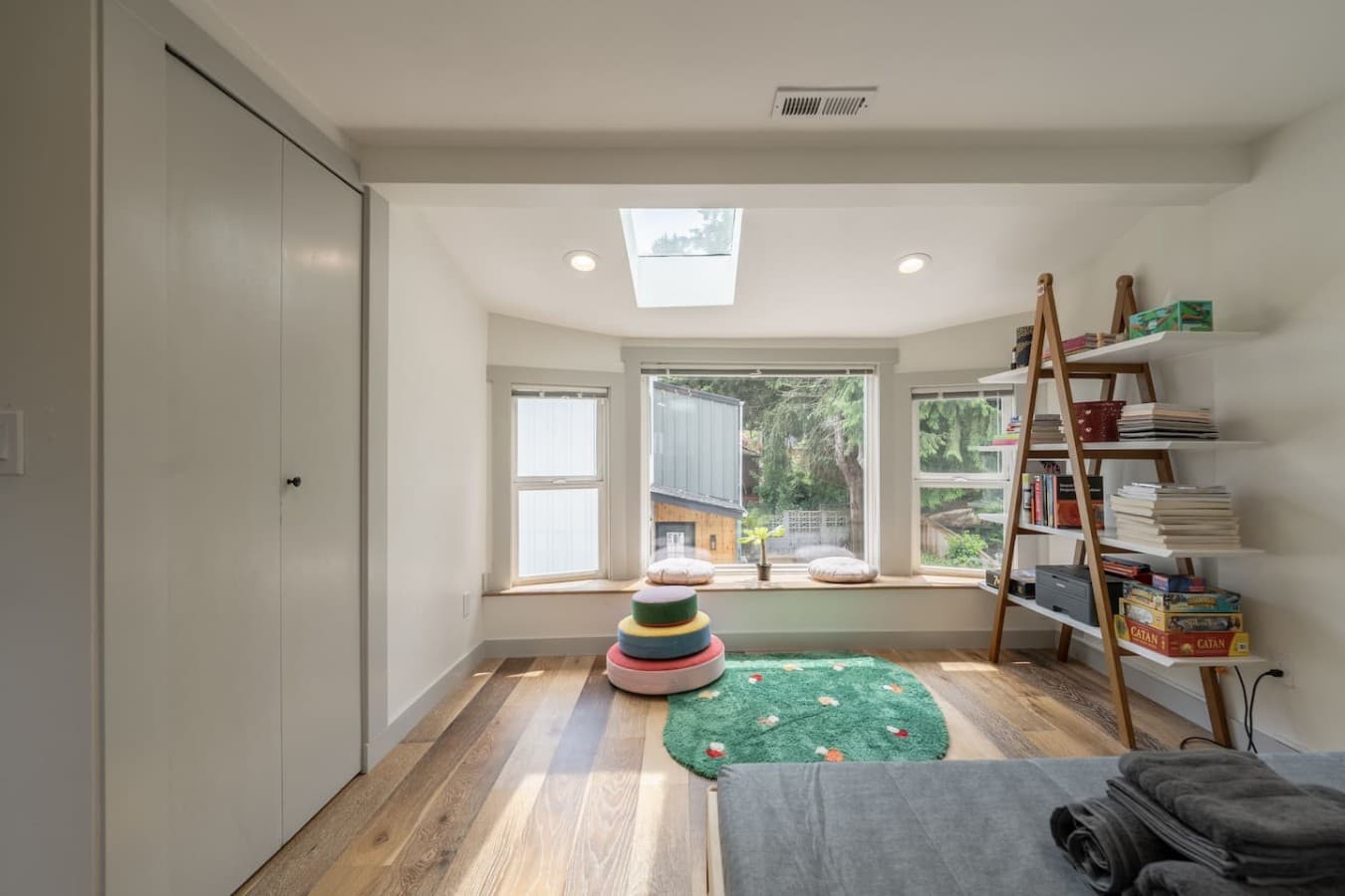 Sunny corner nook with large windows and playful touches creating a relaxing space for reading or quiet mornings.