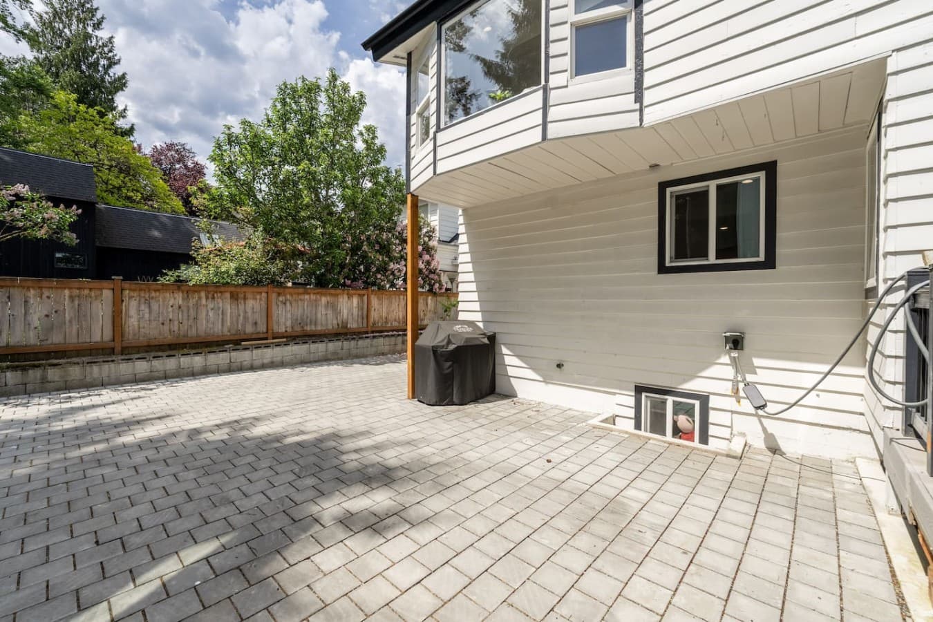 Expansive backyard patio with open space for entertaining, lounging, and enjoying the outdoors.