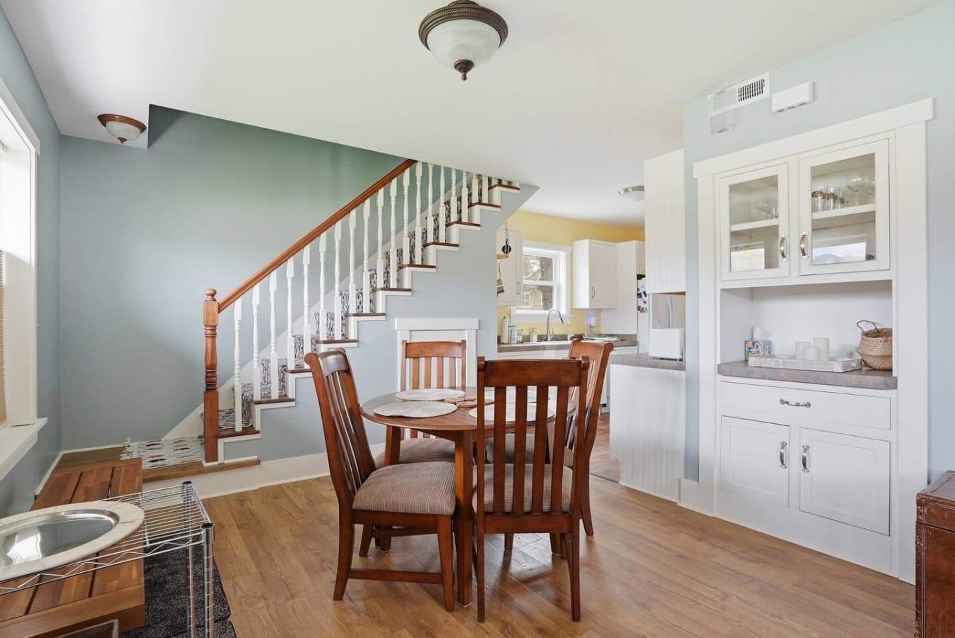 Inviting dining table perfectly positioned near the kitchen and staircase.