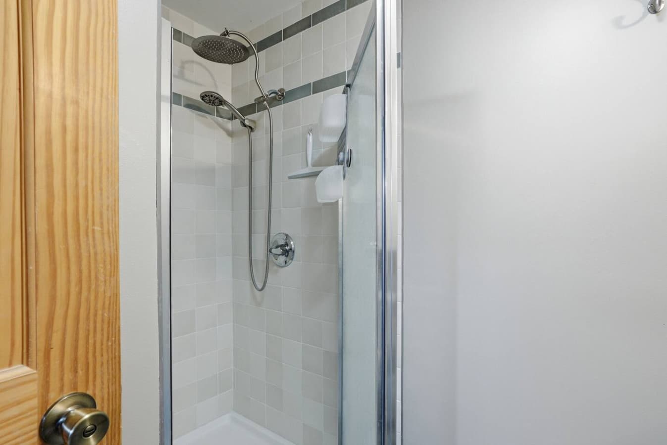 Walk in shower with sleek tile and glass enclosure.